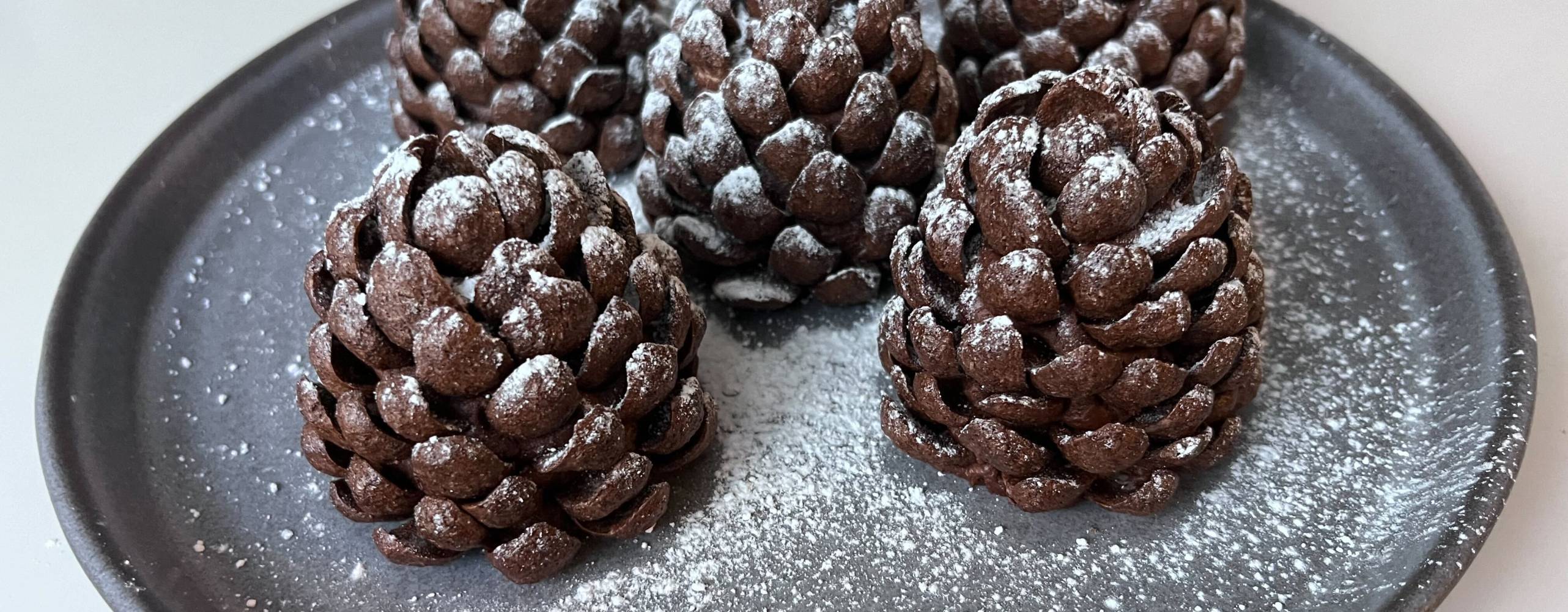 En tallrik med fem kladdkakekottar på ett vitt bort