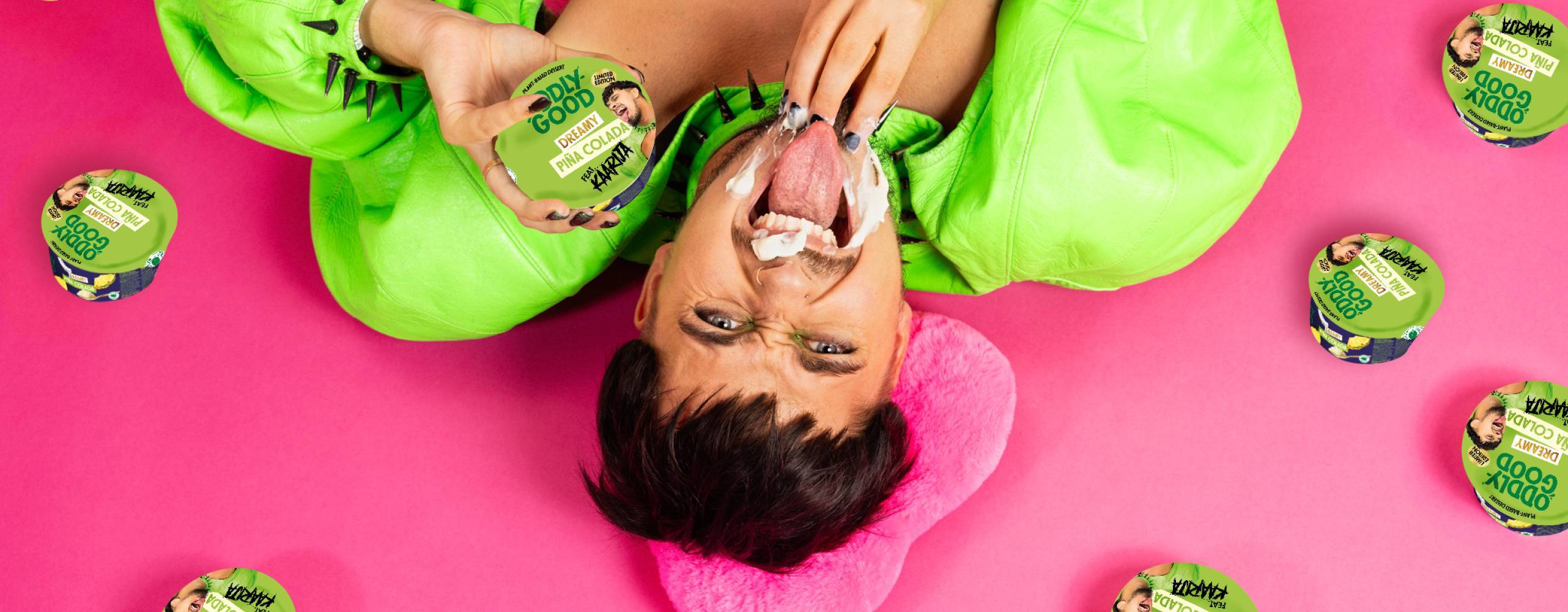 En man i gröna kläder ligger på en rosa bakgrund