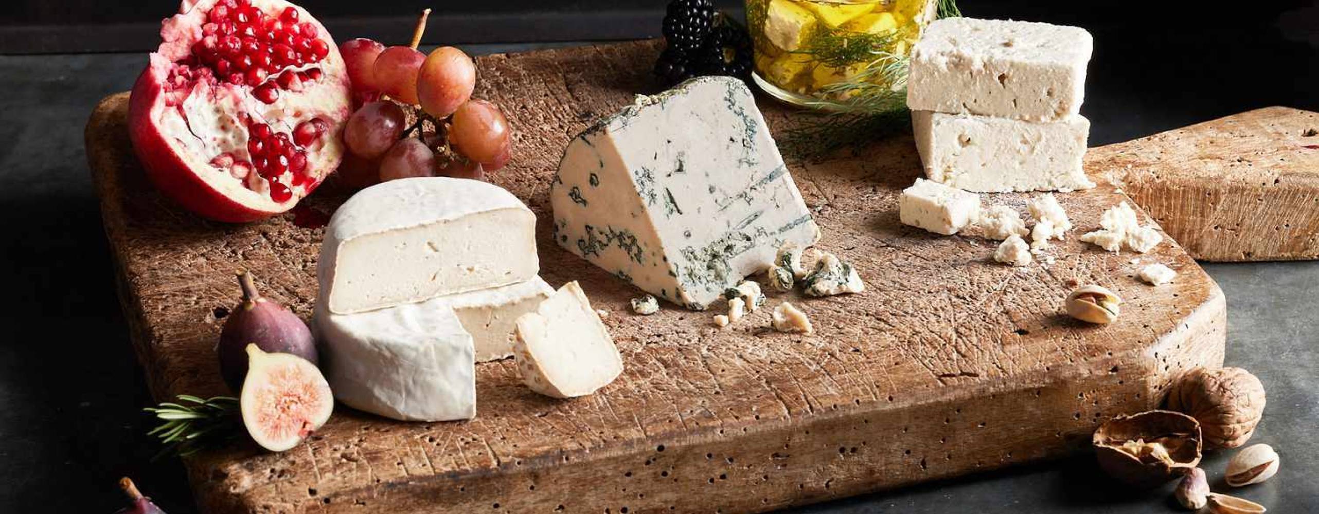 Flera olika veganska ostar på en skärbräda.