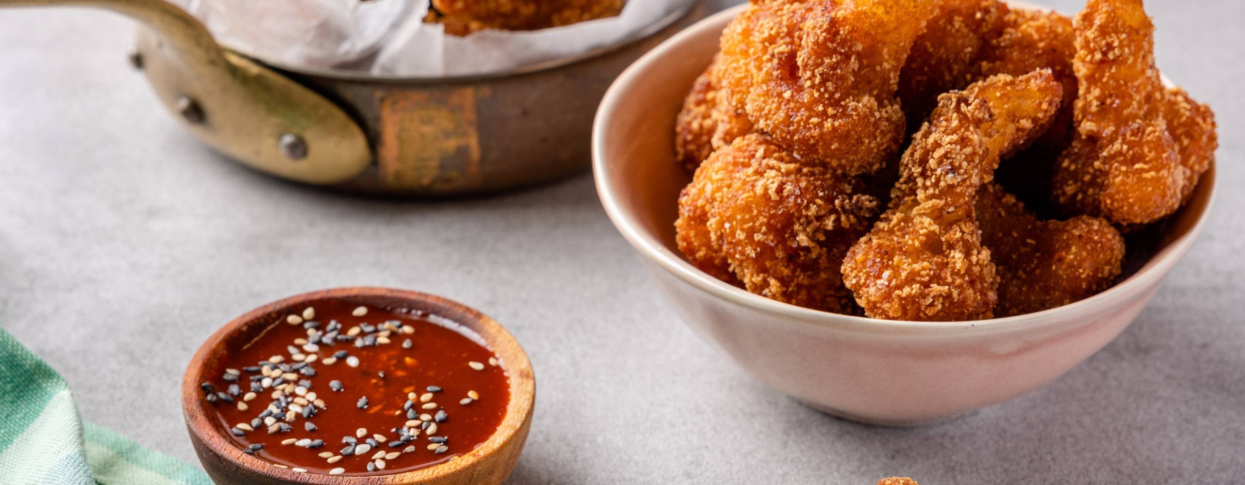 Två skålar med friterad blomkål i, samt en mindre skål med sås.