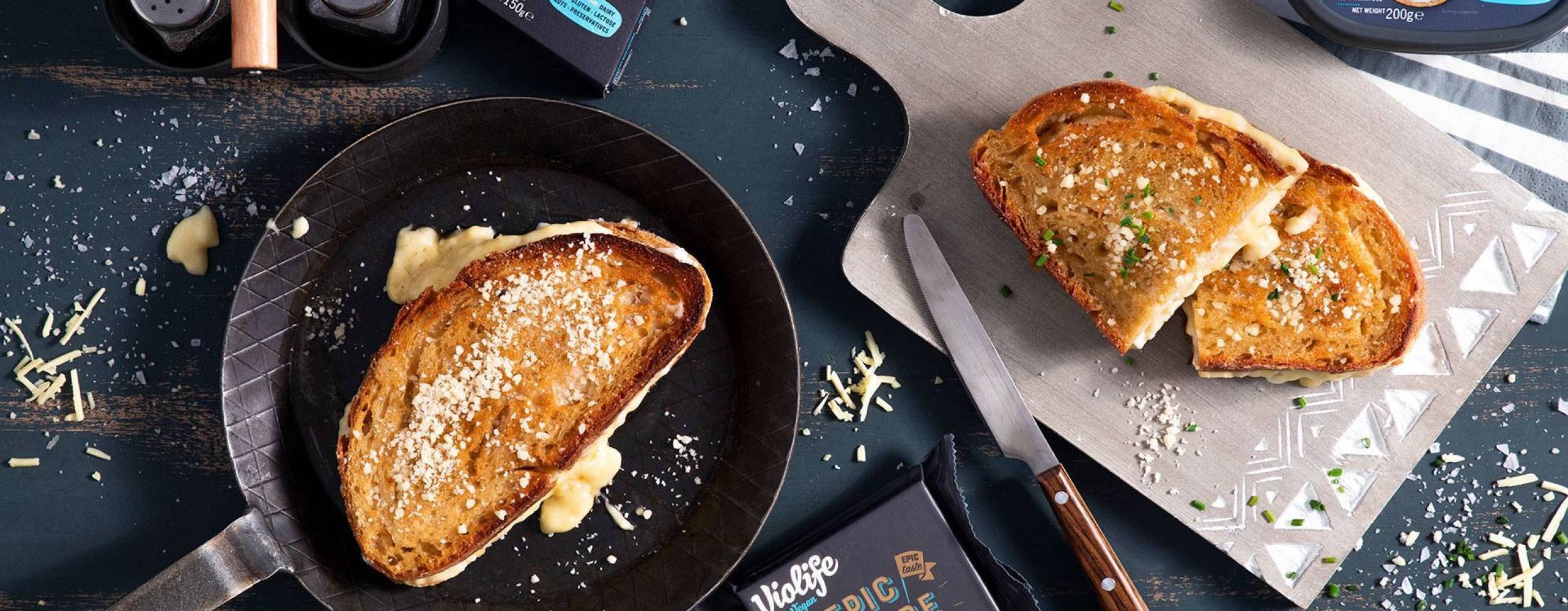 Vegansk toast i en stekpanna och en på en skärbräda