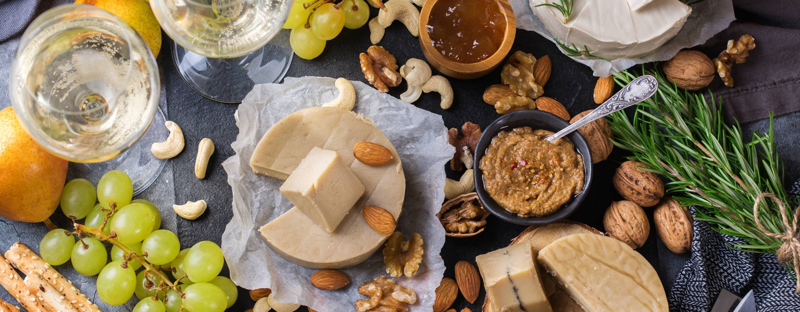 Charkfat serverad med ekologisk icke-mejerijäst råost från cashewnötter med snacks, frukt. Vegansk, vegetarisk, växtbaserad mat, näring och bantning, hälsosam kostkoncept.