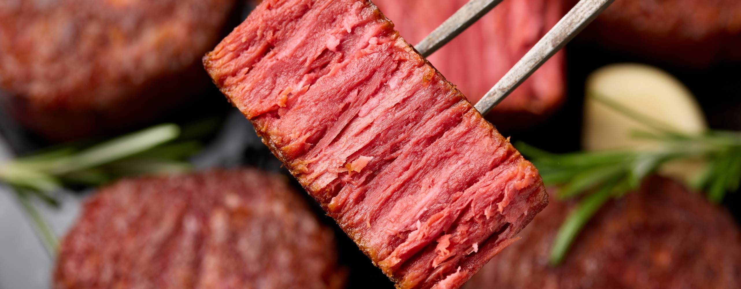 Slices of plant based vegan meat steak on meat fork. Alternatives meat. Eco friendly healthy food,