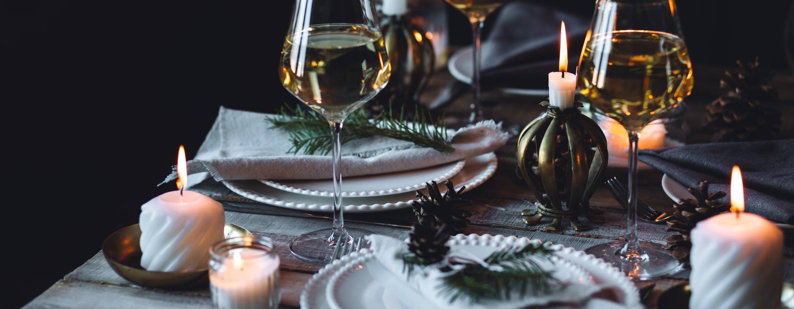 Rustic Scandinavian style zero waste eco-friendly dinner table decor for Christmas or new year family celebration. Wooden table, natural elements like pine cones, fir tree branches, candles