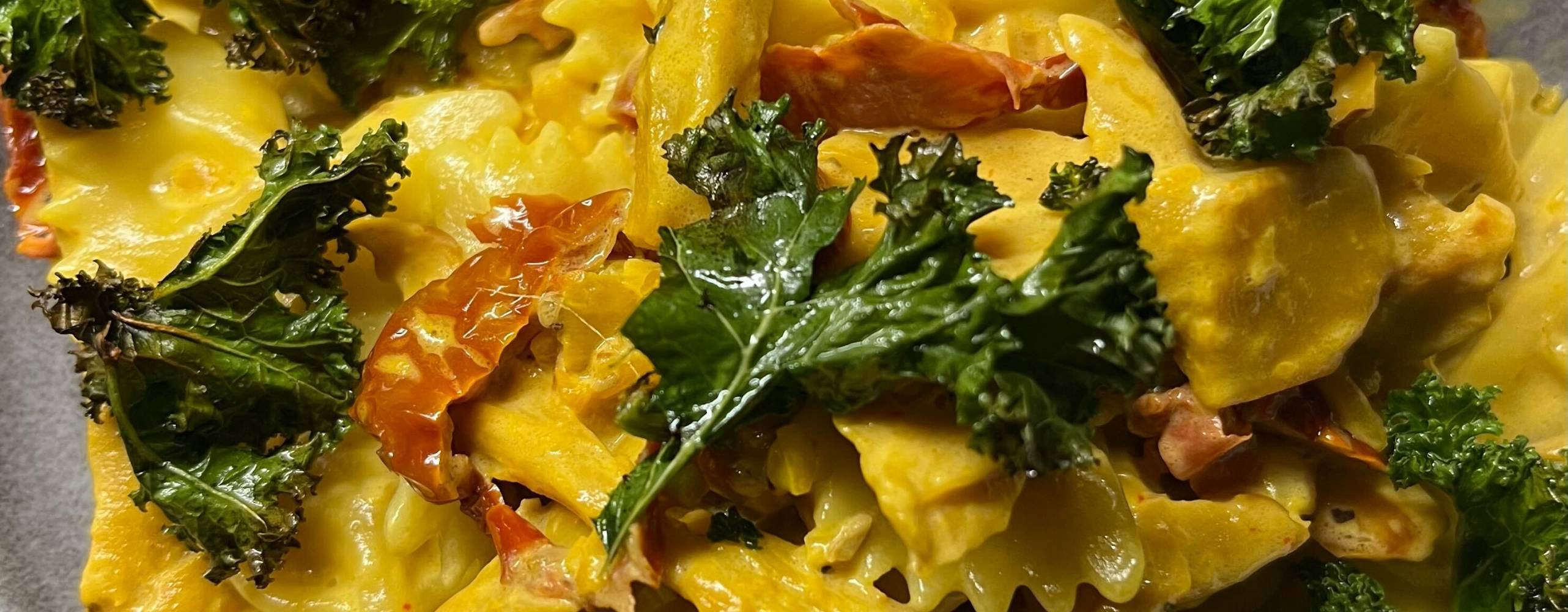 En djuptallrik med saffranspasta, grönkål och soltorkade tomater