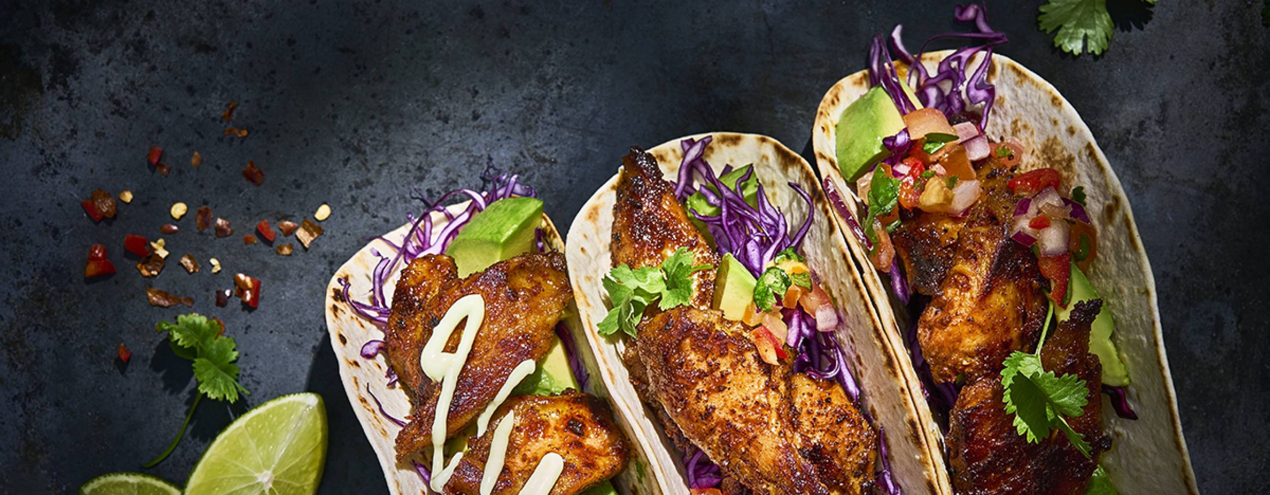 Tre mjuka tacos på ett svart bord