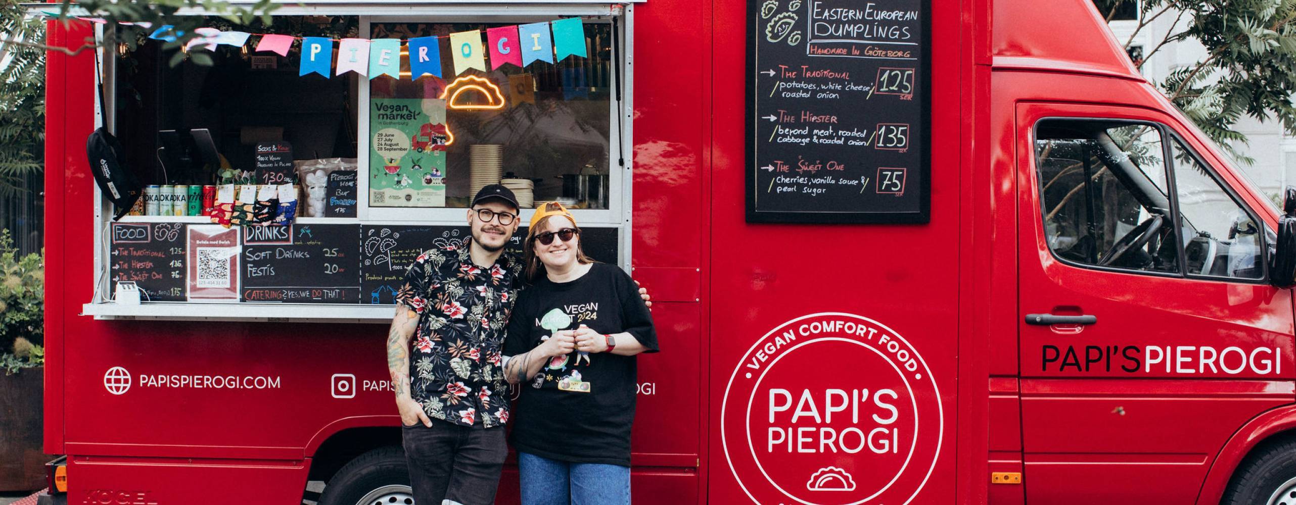 Två personer framför en röd van