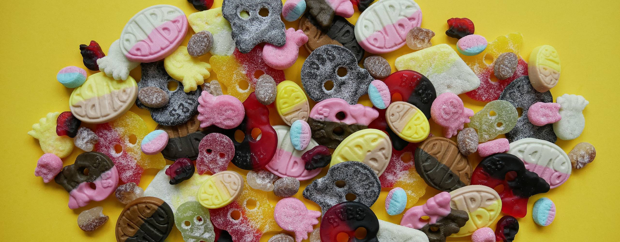 En hög med veganska godisar på en gul bakgrund.