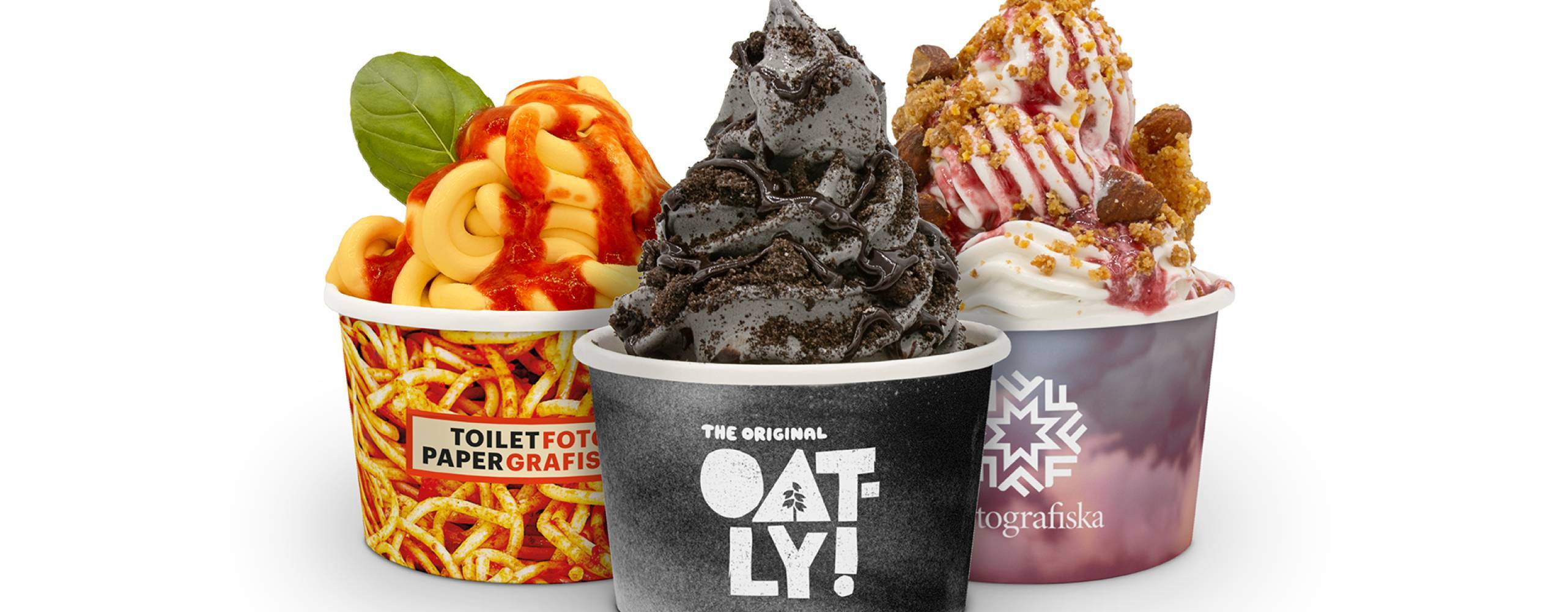 Tre veganska mjukglassar i olika färger i bägare mot en vit bakgrund