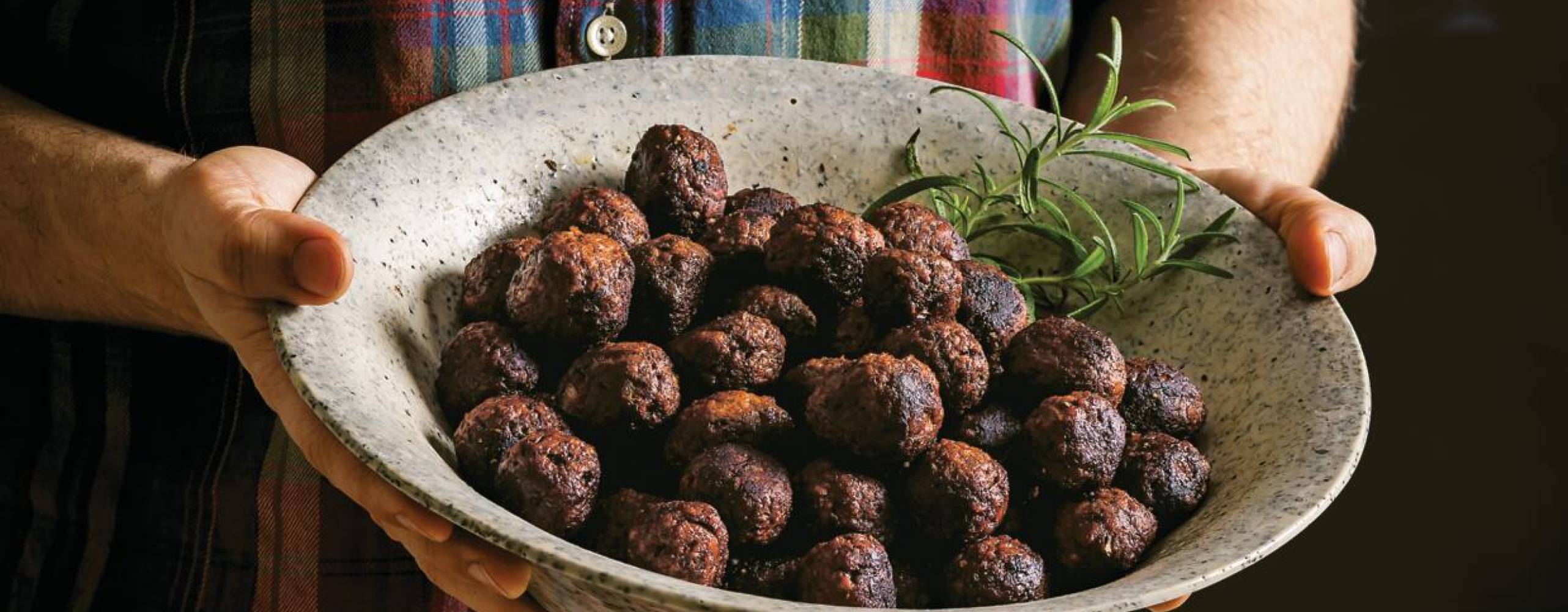 En man som håller i en skål med veganska julköttbullar