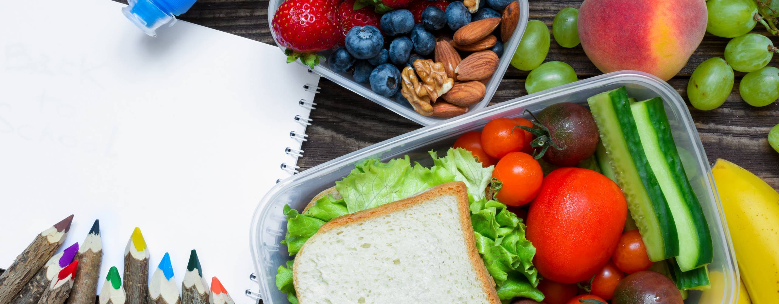 Bild på smörgås, frukt, ett A4 och pennor