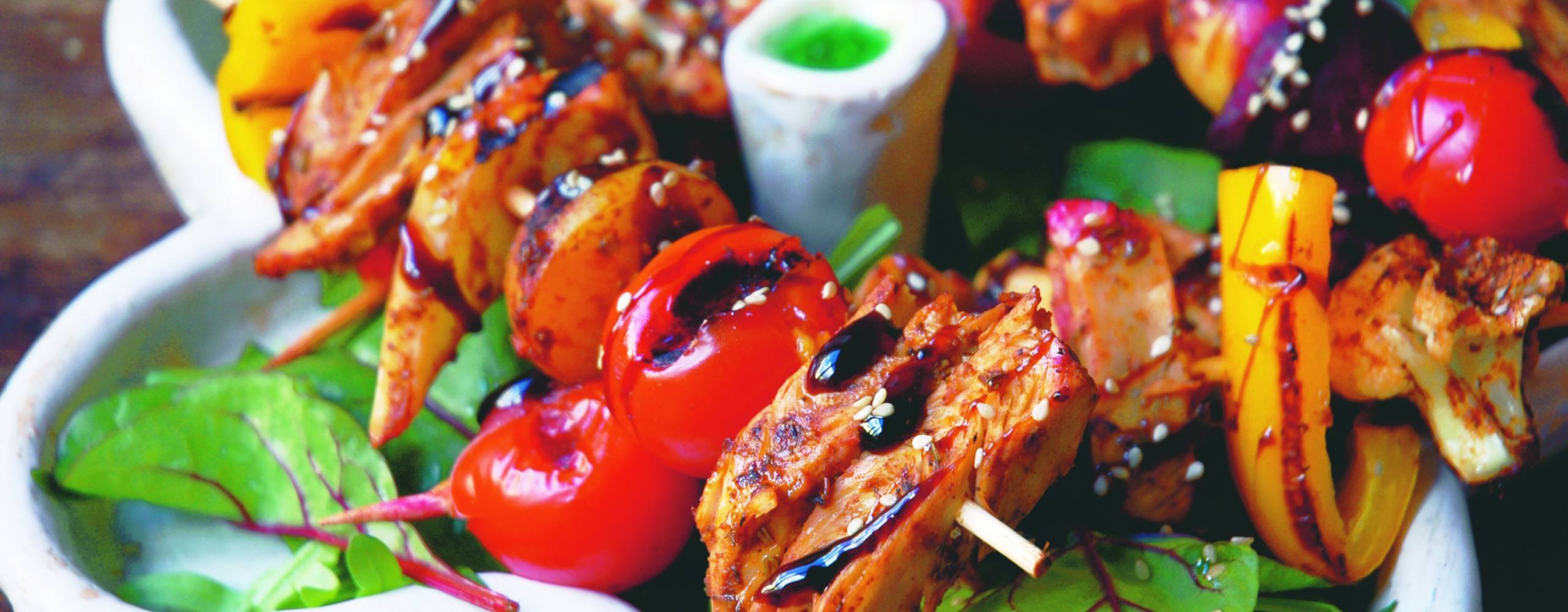 Grillspett i BBQ-marinad med sallad på ett vitt fat